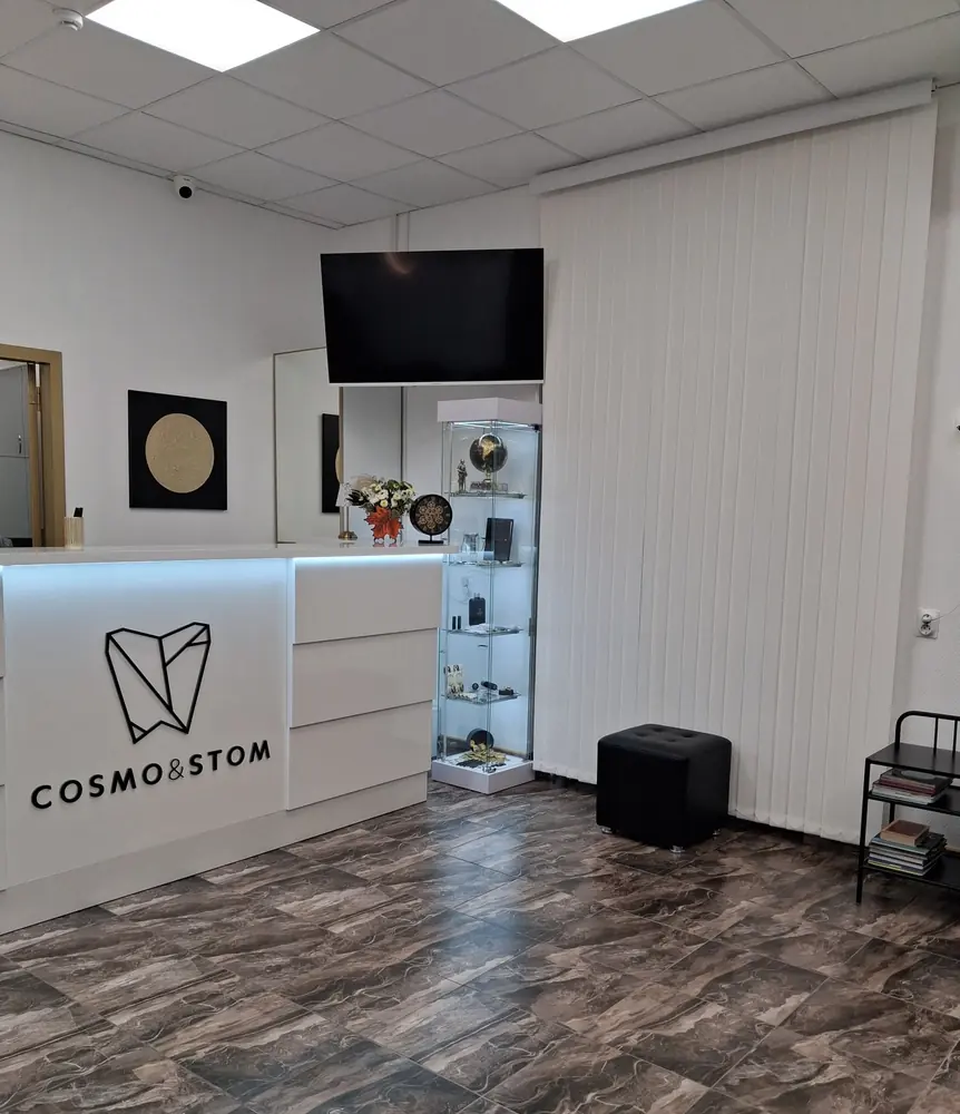 Стойка ресепшен с логотипом CosmoStom в холле клиники